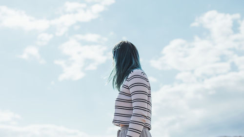 Rear view of woman standing against sky