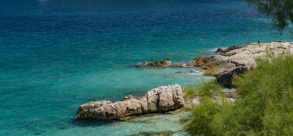 High angle view of rocks on sea shore