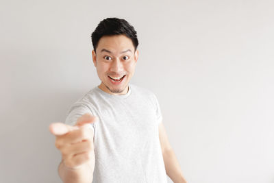 Portrait of young man standing against white background