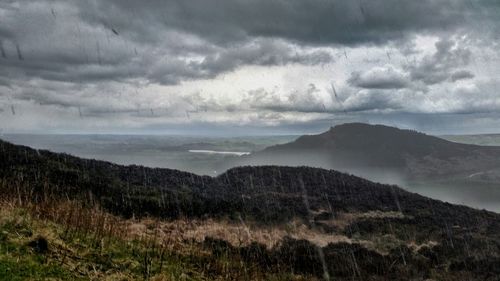 Scenic view of mountains against cloudy sky