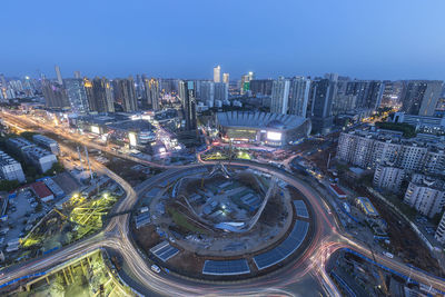 High angle view of illuminated buildings in city against clear sky