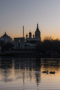 Reflection of cathedral in water at sunset and two ducks