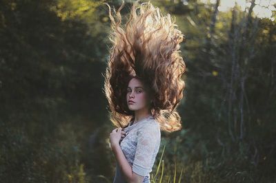 Portrait of woman standing by tree