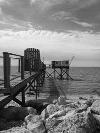 Pier on beach against sky
