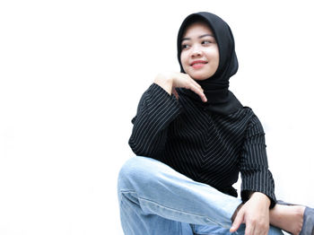 Portrait of a smiling young woman against white background