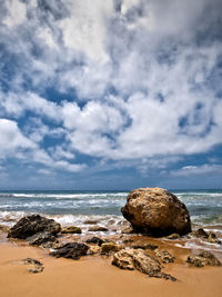 Rocks on beach against sky