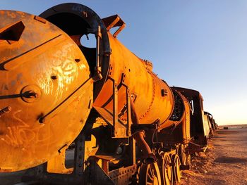 Rusty train at shunting yard against clear sky