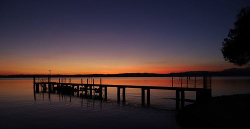 Silhouette pier on sea against sky during sunset