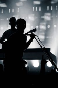 Silhouette singer and guitarist performing during music concert
