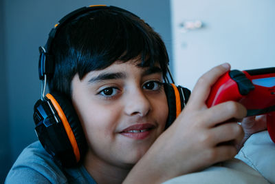 Portrait of boy wearing headphones holding a joystick