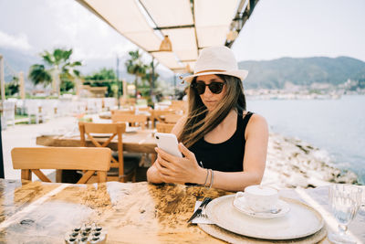 Woman using smart phone at restaurant