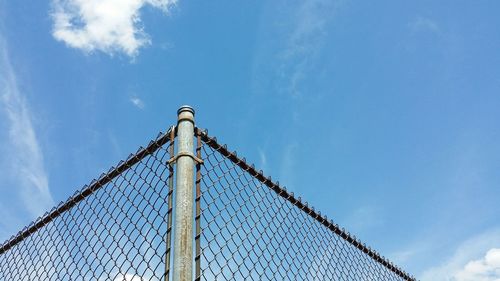 Low angle view of chainlink fence against sky