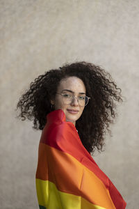 Woman with eyeglasses wrapped in rainbow flag