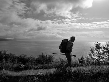 Man standing on shore against sky