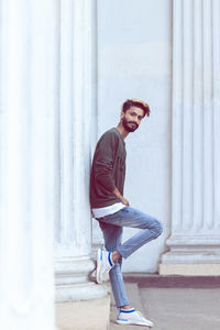 Portrait of young man against column