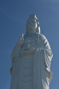 Low angle view of statue against blue sky