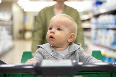 Portrait of cute baby boy looking through window