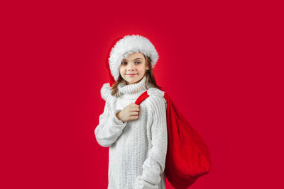 Christmas happy child with present sack. new year small girl in santa claus hat