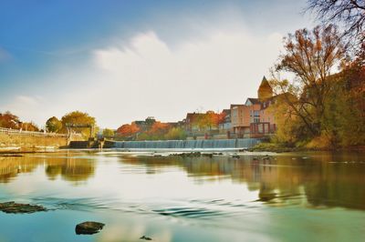 Scenic view of lake by buildings against sky