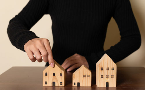 Midsection of man holding model house