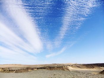 Scenic view of desert against blue sky