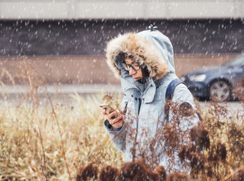 Full length of man using mobile phone on snow