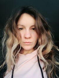 Portrait of woman with long hair against black background