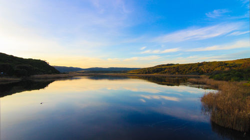 Scenic view of lake against sky at sunset