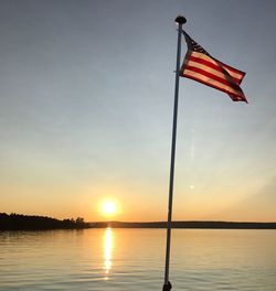 Scenic view of flag against sky during sunset