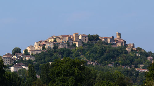 Buildings in city against clear blue sky