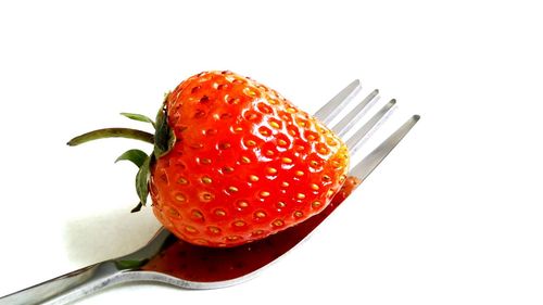 Close-up of strawberry over white background