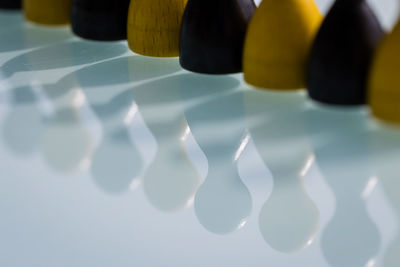 Bowling pins arranged on glass table with reflection