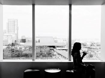 Woman looking through window