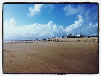 Scenic view of beach against cloudy sky