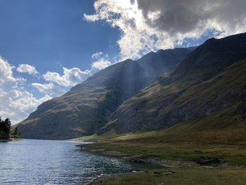 Scenic view of lake by mountains against sky