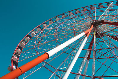 Low angle view of ferris wheel against blue sky