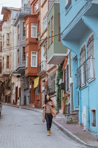 Rear view of woman walking on street in city