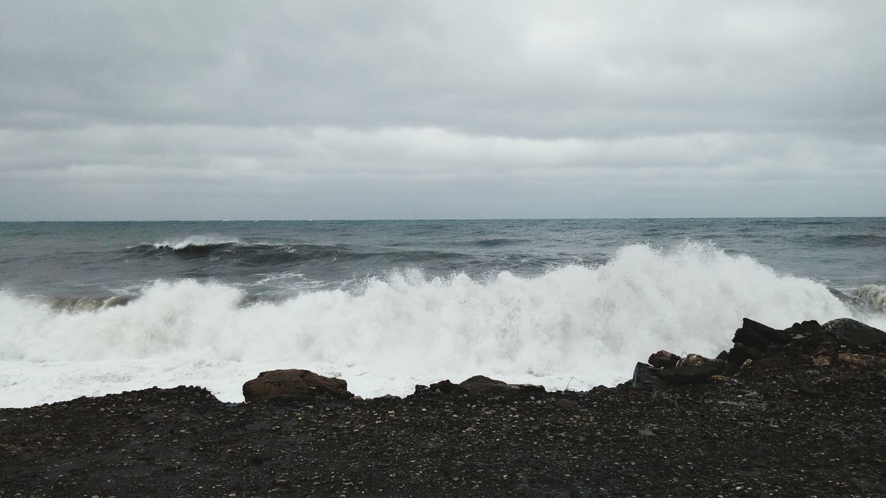 sea, water, horizon over water, wave, surf, sky, scenics, beauty in nature, beach, motion, splashing, shore, nature, cloud - sky, power in nature, tranquil scene, rock - object, cloudy, tranquility, idyllic