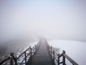 View of footbridge in snow during winter