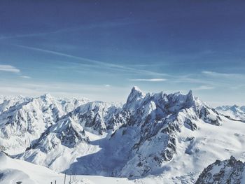 Scenic view of snow mountains against blue sky