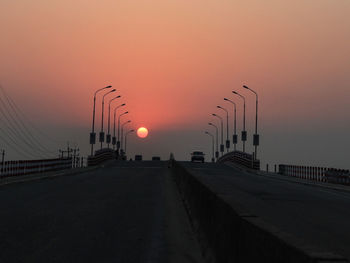 Street lights against sky during sunrise 