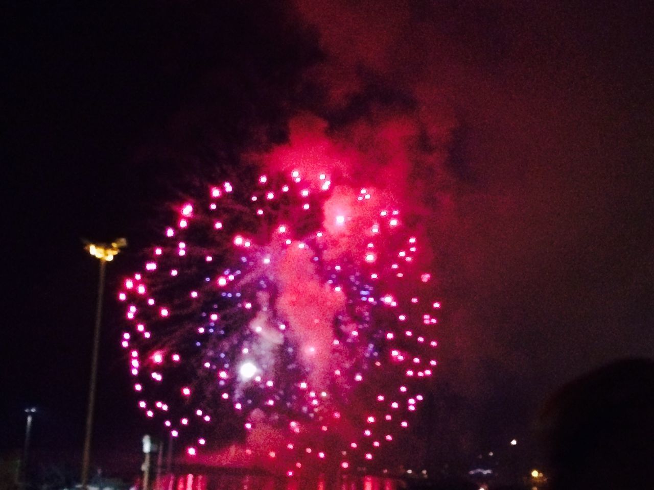 illuminated, night, celebration, arts culture and entertainment, firework display, low angle view, sky, exploding, glowing, firework - man made object, lighting equipment, event, architecture, long exposure, built structure, motion, ferris wheel, building exterior, multi colored, celebration event