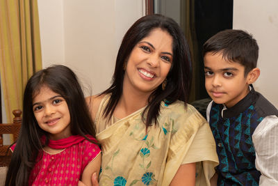 Portrait of smiling mother with daughter and son at home