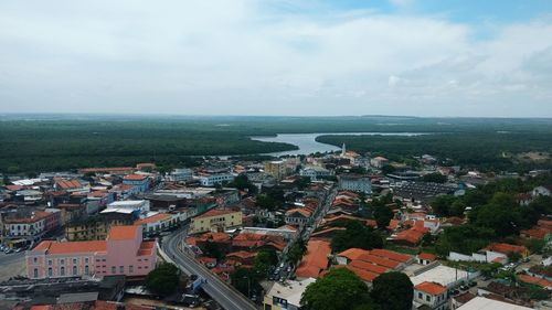 High angle view of cityscape by sea against sky