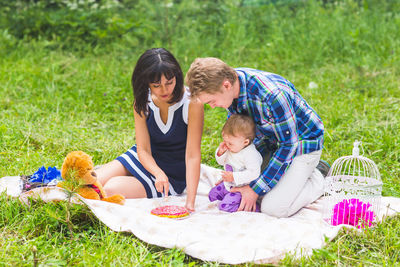 Rear view of women sitting on grass against plants