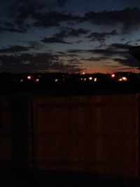 Silhouette of illuminated building against sky at night