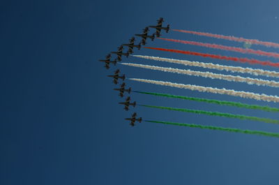 Low angle view of airplane flying against clear blue sky