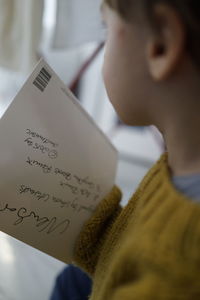 Close-up of boy holding paper with text