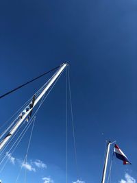 Low angle view of sailboat against clear blue sky