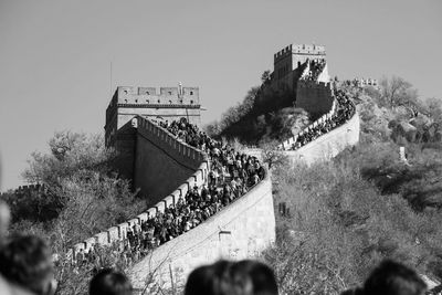 Low angle view of people walking on steps against sky